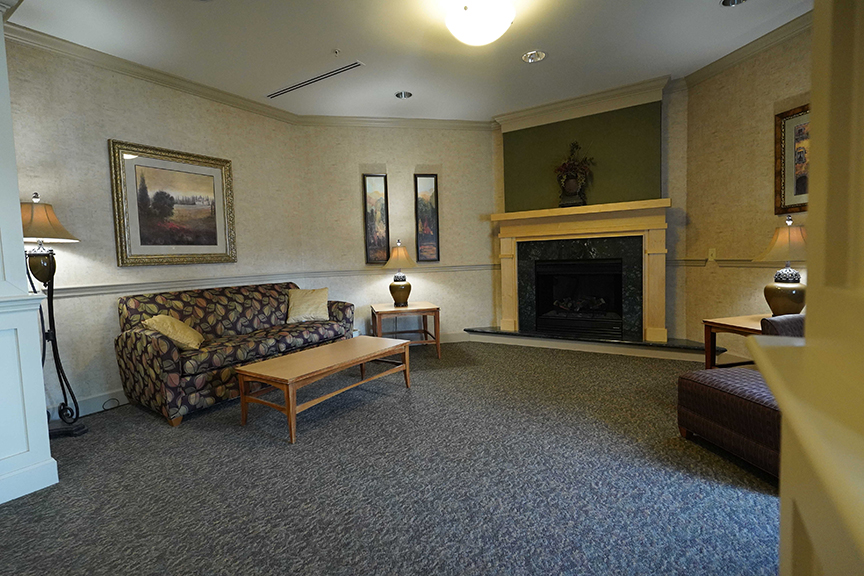 Sofa and wooden center table in resident lounge- Arbors at Oregon